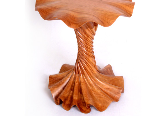 Made from cherry wood; 21"L 21"W 23.5"H. This piece was created in three major sections, with the center mortise and tenoned into the base and top. I stated the initial shaping with a mini chainsaw and then proceeded to the detail carving with die grinders. It was then sanded and finished with a clear polyurethane.